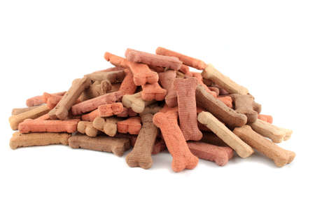 Pile of dog biscuits in the shape of a bone on a white background (not isolated)の写真素材