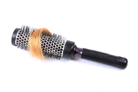 Curling bristle  brush with lock of blonde hair on a white backgroundの写真素材