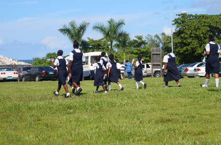 Students from the Bahamas dressed in school uniform go to a gathering or festival in the outdoors in Nassauのeditorial素材