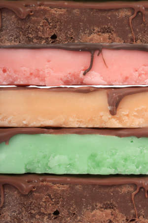Close up of fudge bar pile in different colors and flavors covered in chocolateの写真素材