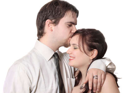 Cute young couple with man kissing woman's forehead,  together on a white backgroundの写真素材