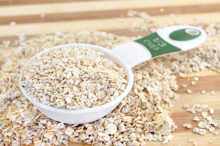 Serving of dry Oatmeal in a measuring cup ready for cooking
