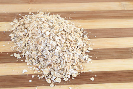 Serving of dry Oatmeal on a wooden board ready for cooking