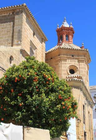 Beautiful church steeple displaying Moorish architecture with orange tree in Osuna, Andalusia, Spainの写真素材