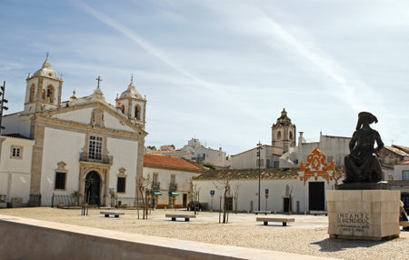 Public square in Faro, Portugal churches in view under a blue sky