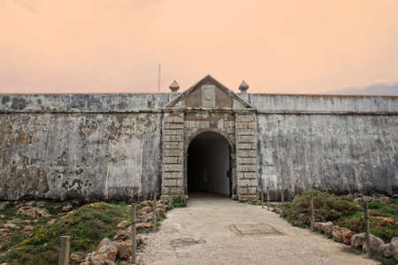 Rugged terrain surround the fortress entrance in Ponta de Sagres, Algarve, Portugal  の写真素材