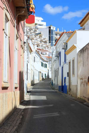 Narrow cobblestone street in old town Albufeira showing condos, Algarve, Portugalの写真素材