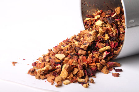 Dried loose orange blossom tea spilling out of a tin ready to steep and brew on a white backgroundの写真素材