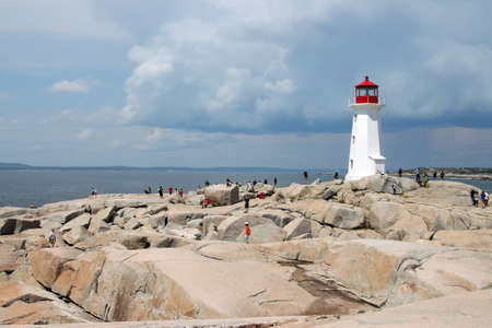August 6, 2014, Peggy's Cove, Nova Scotia: People walking around the rocks of the lighthouse in touristic Peggy's Cove, Nova Scotia, Canada のeditorial素材