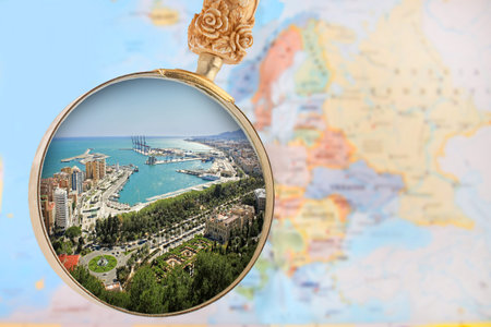 Looking in on Malaga Spain with a magnifying glass or loop with European map in the background