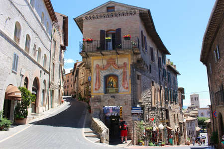 ASSISI, ITALY - JUNE 24, 2014: Hilly Street in the town of Assisi Italy showing souvenir shops for touristsのeditorial素材