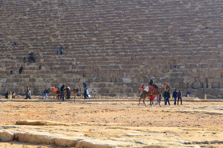 GIZA PLATEAU, EGYPT - JAN. 31, 2016: Tourists and visitors at the bottom of the Grand Pyramid...