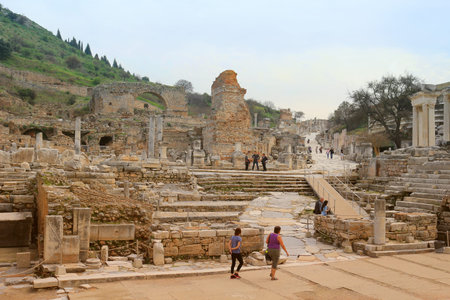 EPHESUS, TURKEY - FEBRUARY 17, 2016: Tourists walk down the marble walkway in Ephesus, Turkey in the...