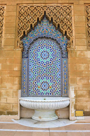 Beautiful decorative mosaic  ceramic tile fountain with ornate arch in Morocco, Africaの写真素材