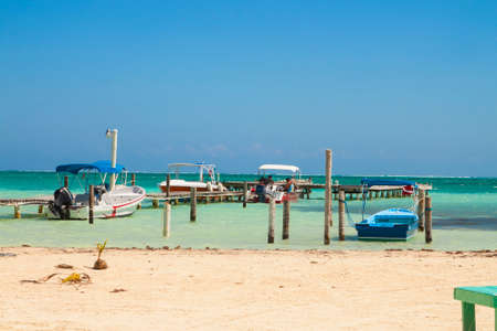 Caye Caulker, Belize - February 28, 2017: Beautiful tropical shore  with pier  for boats on the  island of Caye Caulker on the Barrier Reef in the Caribbean Seaのeditorial素材