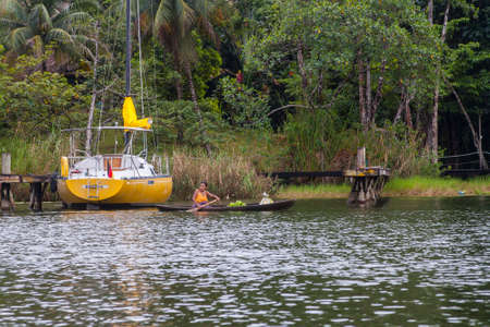 Rio Dulce, Guatemala - 2017-03-03: Woman on a small wooden boat taking her fruits and vegetables on   Rio Dulce, Guatemala,のeditorial素材