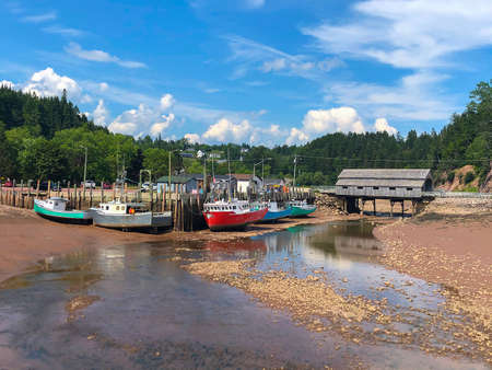 Colorful fishing boats in Atlantic Canada on the Bay of Fundy, St. Martins, New Brunswick during low tideのeditorial素材