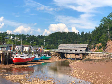 Colorful fishing boats in Atlantic Canada on the Bay of Fundy, St. Martins, New Brunswick during low tideのeditorial素材