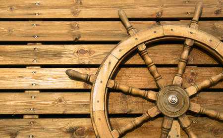 Old wooden wheel on a wooden wallの写真素材