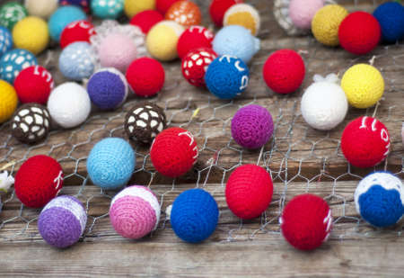 Decorative multi-colored easter eggs hanging on a wooden background wall. Selective focus, shallow FOFの写真素材