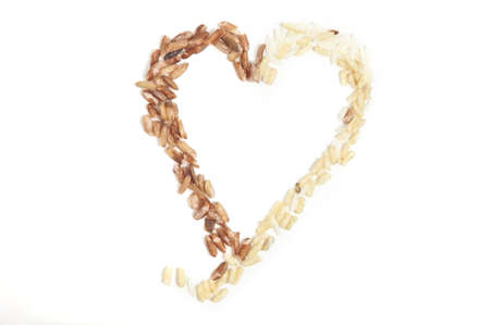 Two types of rice forming a heart isolated on white.の写真素材