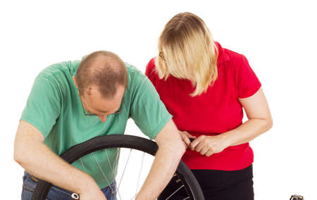 A mechanic repairs the wheel of a bicycleの写真素材
