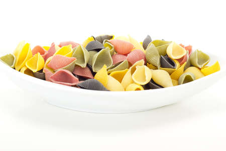 Unboiled italian shell noodles on a plateの写真素材