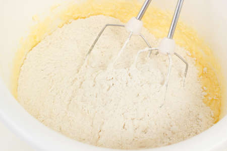 Flour and baking powder mixed into the doughの写真素材