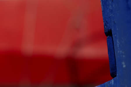 Old boat painted in blue and red, blue detail sharp, red background full blurry	の写真素材