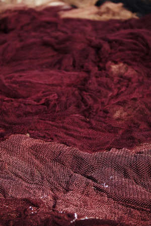 Fishing net in 1 color laying on ground, sharp foreground, blurry backgroundの写真素材