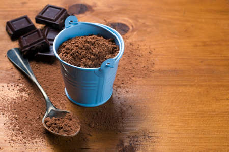 Chopped chocolate and cocoa powder on wooden backgroundの写真素材