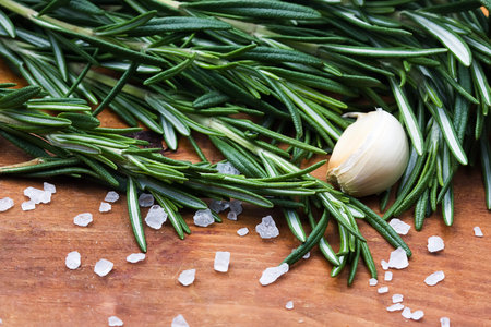 Fresh rosemary and  garlic  on old wooden backgroundの写真素材