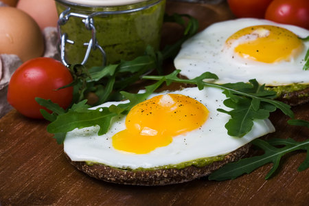 croque-madame with fried egg , pesto sauce and rucola,close up. Traditional French Toasted Sandwich