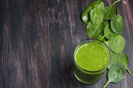 Green spinach smoothie on wooden boardの写真素材