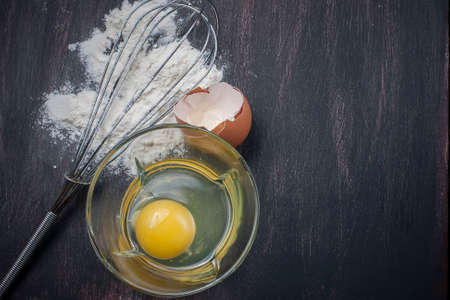 Flour and eggs on a wooden table, means for making breadの写真素材