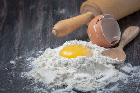 Flour and eggs on a wooden table, selective focusの写真素材