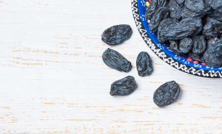 Black raisins on a wooden background , closeupの写真素材