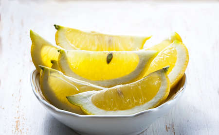 sliced, lemon on a plate on a white background wooden, selective focusの写真素材