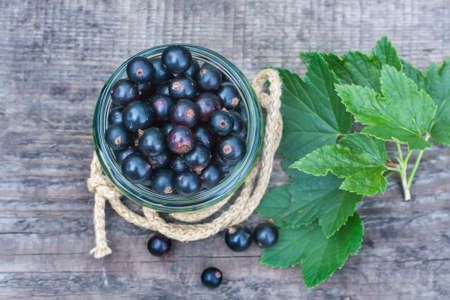 fresh black currant in the glass, on rustic wooden board. Selective focusの写真素材