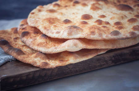 Freshly baked pita bread on a wooden table close-up. Selective focusの写真素材