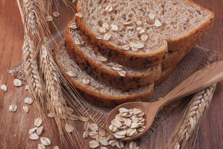 Healthy wholegrain bread on burlap napkin,  located on wood background. Selective focusの写真素材