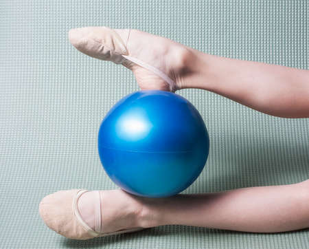 Gymnast's feet in toe shoes with red ballの写真素材