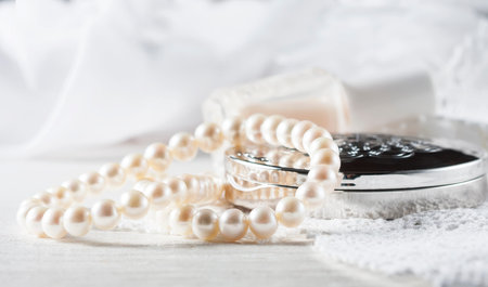 White pearl necklace, women's accessories, on handmade lace background. Selective focus.の写真素材