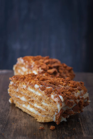Slice of homemade layered honey cake. Russian cake Medovik with honey. Selective focus
