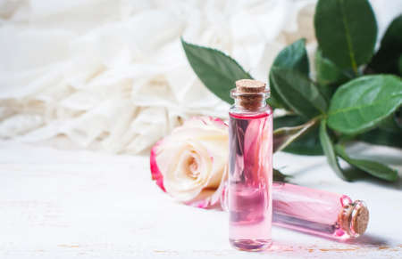 perfumed rose water in a bottle on a wooden table.  Selective focusの写真素材