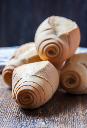 Homemade bread rolls on a dark wooden background. Selective focus