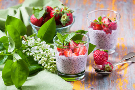 Homemade pink Chia pudding with  fresh strawberries on wooden table. Selective focusの写真素材