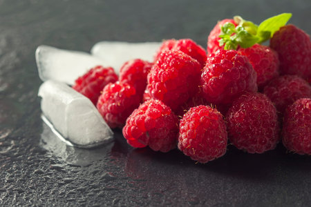 Frame of Fresh Sweet Raspberries with Water Drops on Black background, closeup. Selective focus