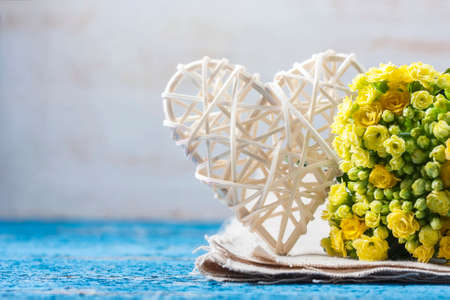 Kalanchoe flowering yellow bouquet and white heart on a wooden background. Selective focusの写真素材