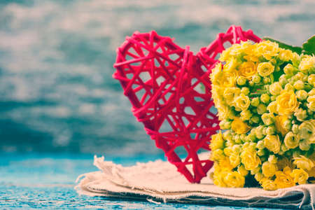 Kalanchoe flowering yellow bouquet and red heart on a wooden background. Selective focusの写真素材